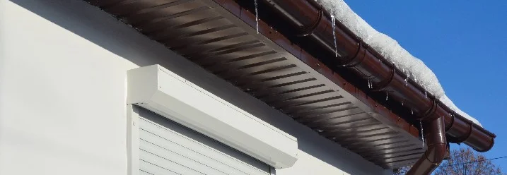 Braune Dachrinne mit Eiszapfen